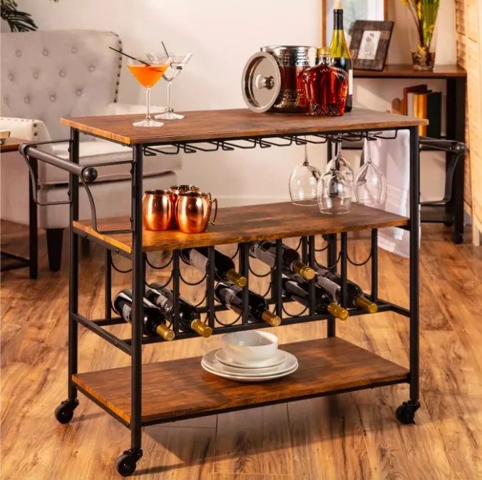 A bar cart stocked with bottles, glasses, and various accessories.