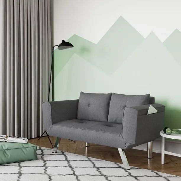 A gray couch set against a green wall
