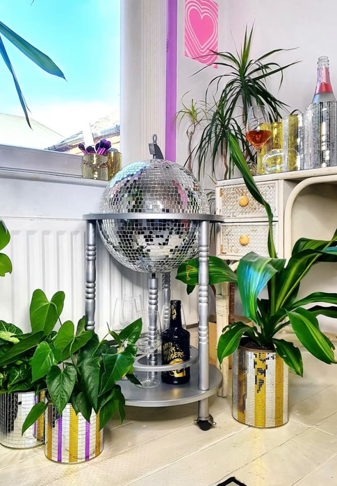 The silver-colored bar cart topped with a shimmering silver disco ball