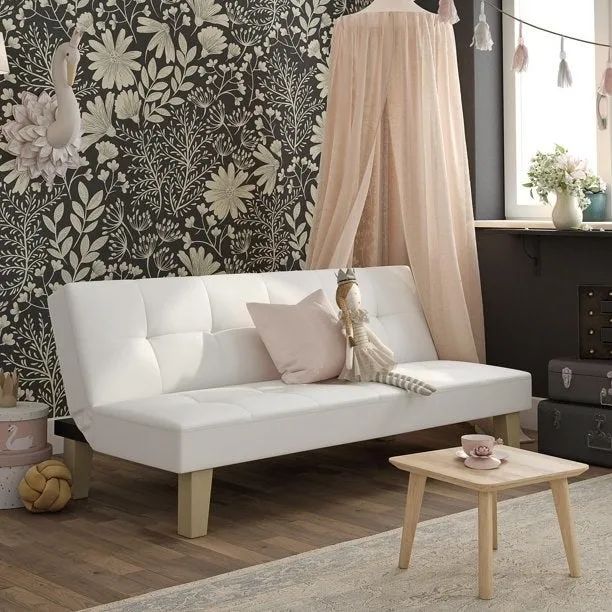 A white futon placed in a child's room, featuring decorative wallpaper.