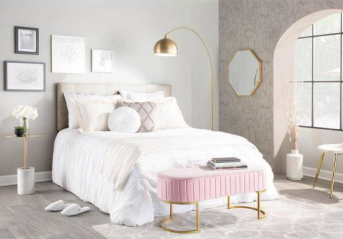a pink pleated bench at the foot of a bed