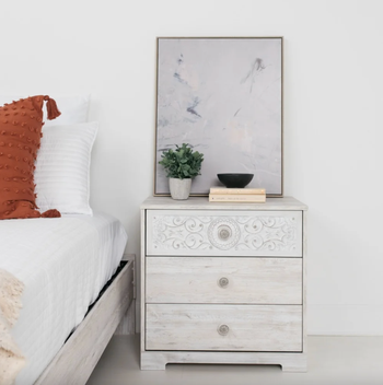 The dresser positioned next to the bed