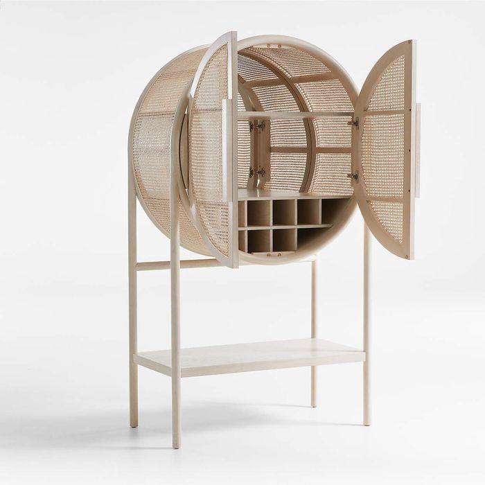 The West whitewashed cane storage cabinet with doors open