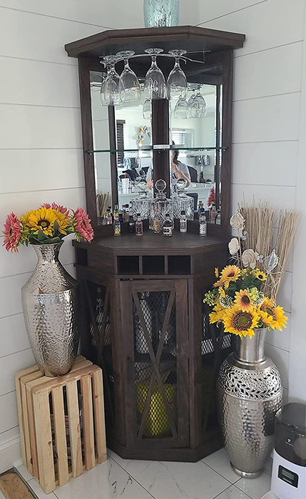 Reviewer image of a tall brown wooden bar cabinet with a mirrored top section