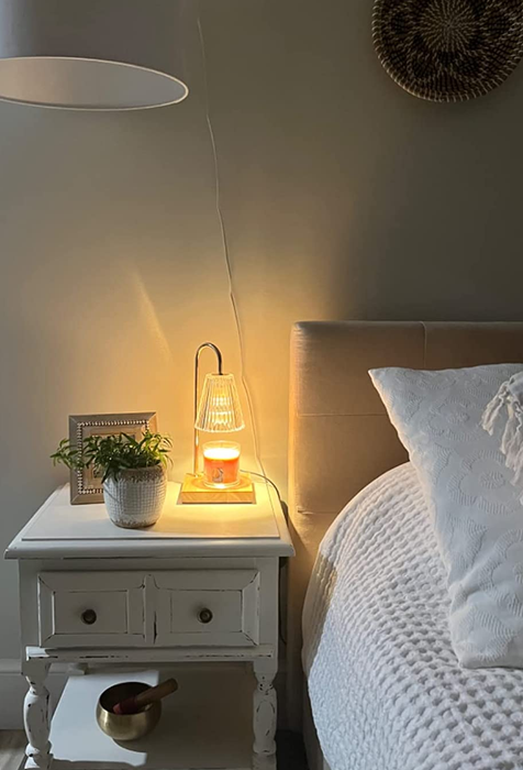 A reviewer showing the lamp on their bedside table