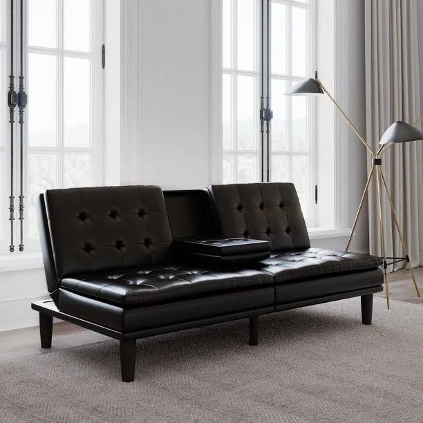 A black faux leather sofa resting on a rug.