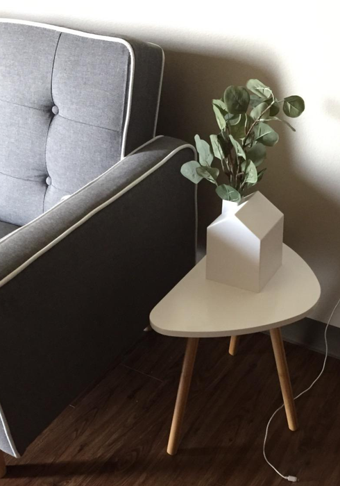 The tissue box repurposed as a vase holding eucalyptus branches