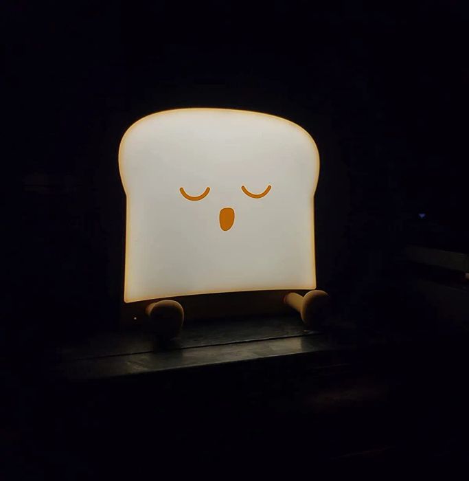 Reviewer photo of the glowing toast night light in a darkened room