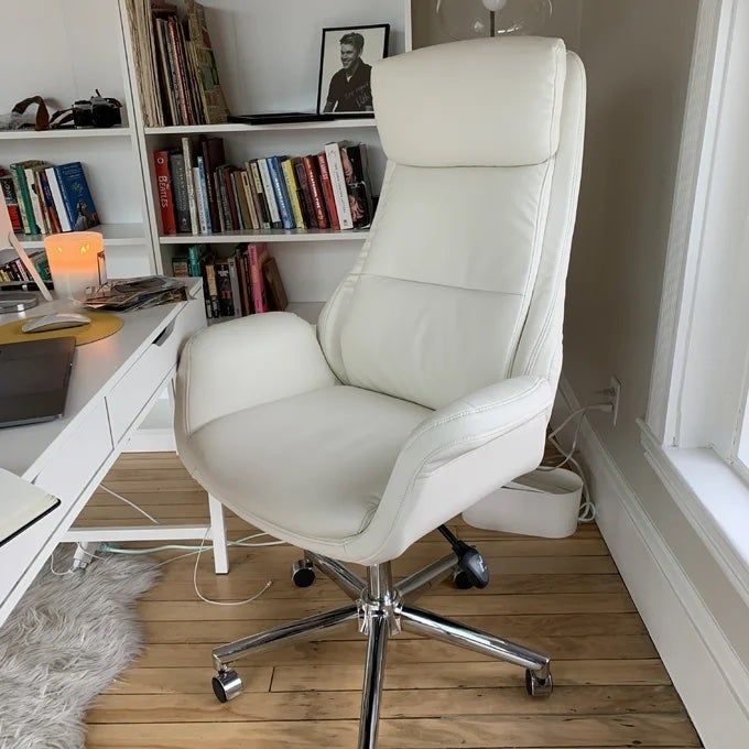 A reviewer’s photo of the white office chair placed neatly at a desk in a home office setup.