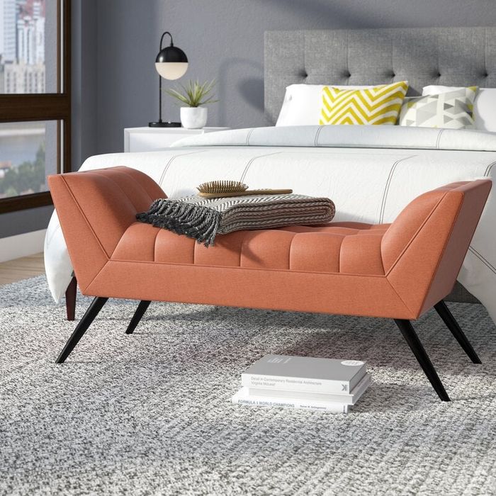 lifestyle photo featuring an orange bench at the foot of a bed