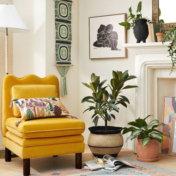 An image of a pink slipper chair featuring soft seat and back cushions, complemented by dark wooden legs.
