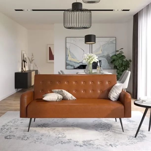 A camel-colored futon placed on a rug in a stylish setting.