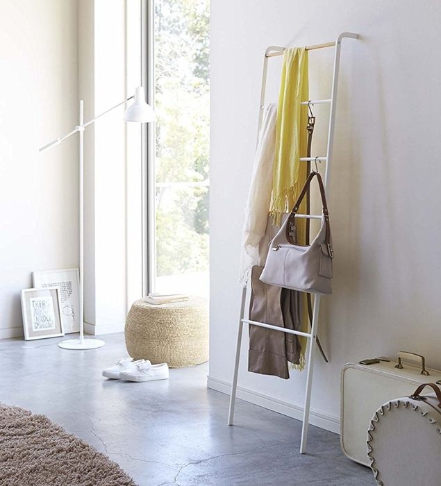 The ladder holding blankets, a bag, a belt, and more
