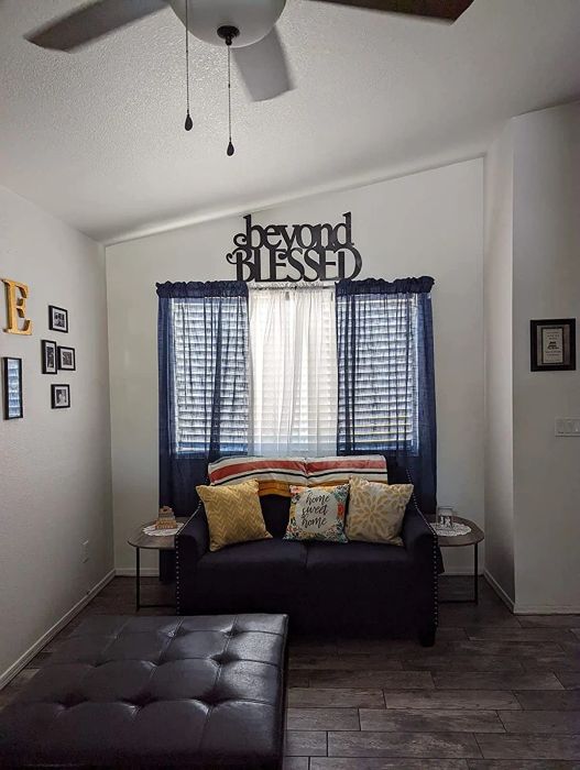 A reviewer's living room with the blue curtains hanging behind a couch