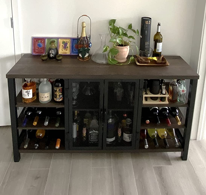 Reviewer image of a stylish bar cabinet with brown wood and black metal, stocked with bottles and glasses