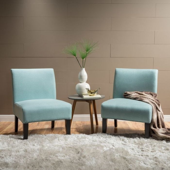 An image of two light blue accent chairs featuring rubber wood legs.