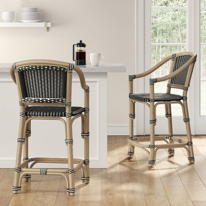 A set of black rattan barstools arranged at a cozy coffee nook.
