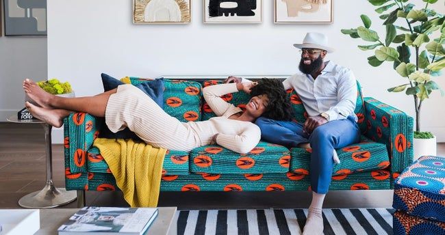 A velvet couch with a striking teal and orange pattern.