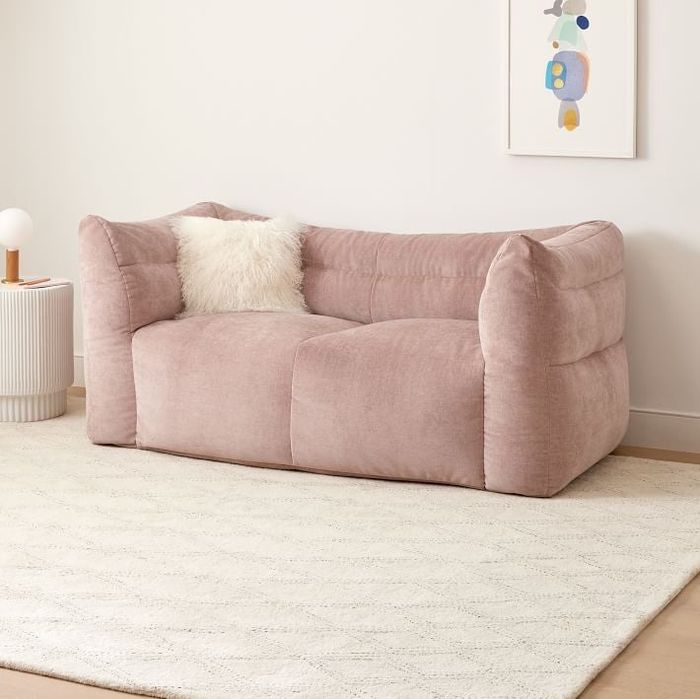 A squishy loveseat that looks like a giant, comfortable pillow shaped like a couch.
