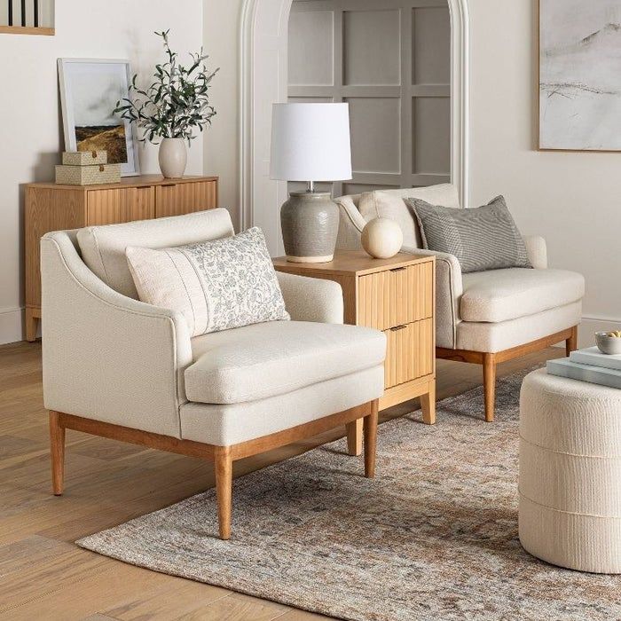 An image of a cream-colored upholstered accent chair with sleek, tapered legs.