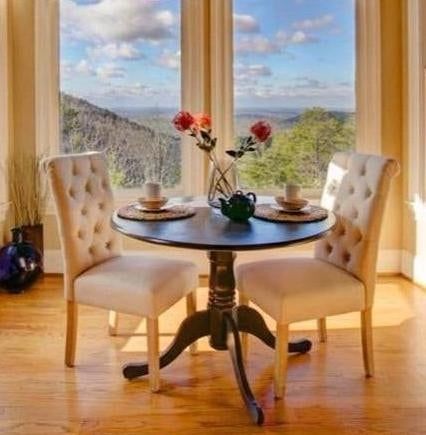 Reviewer image of two white tufted chairs around a small round dining table