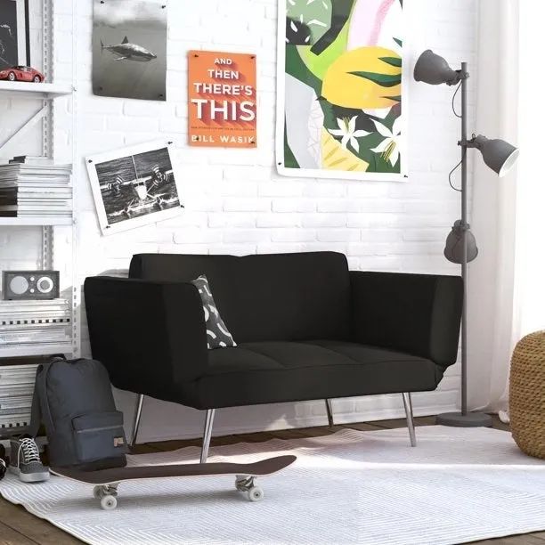 A black futon with artwork hanging above it on the wall.