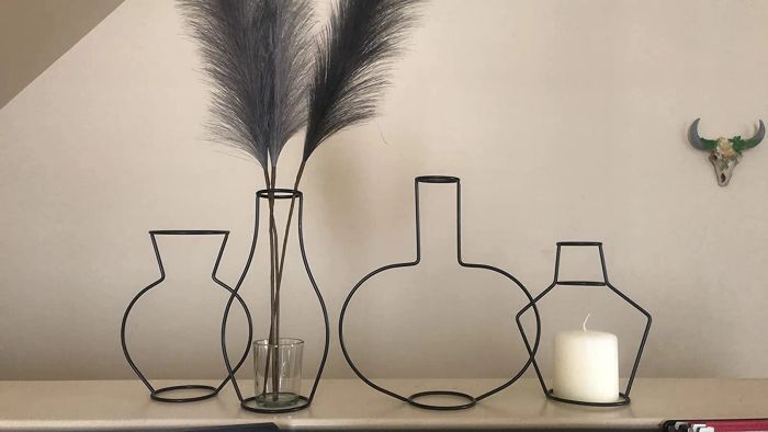 Various vases used to display a pampas feather and a candle holder