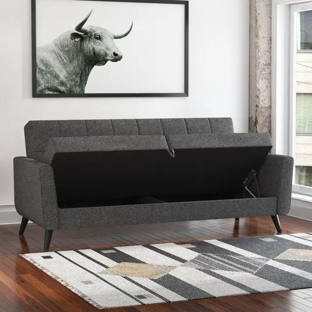 A grey couch with the seat lifted to reveal hidden storage space.