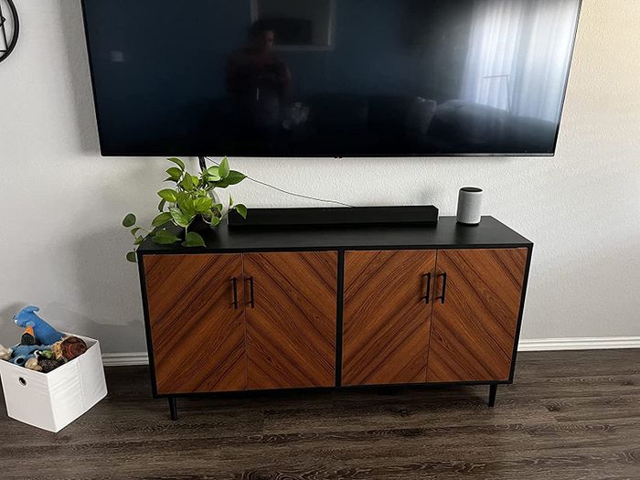 a reviewer’s photo of the black double-door buffet beneath a mounted TV