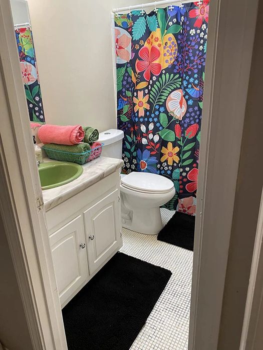 A floral shower curtain on a black background with bold flower prints