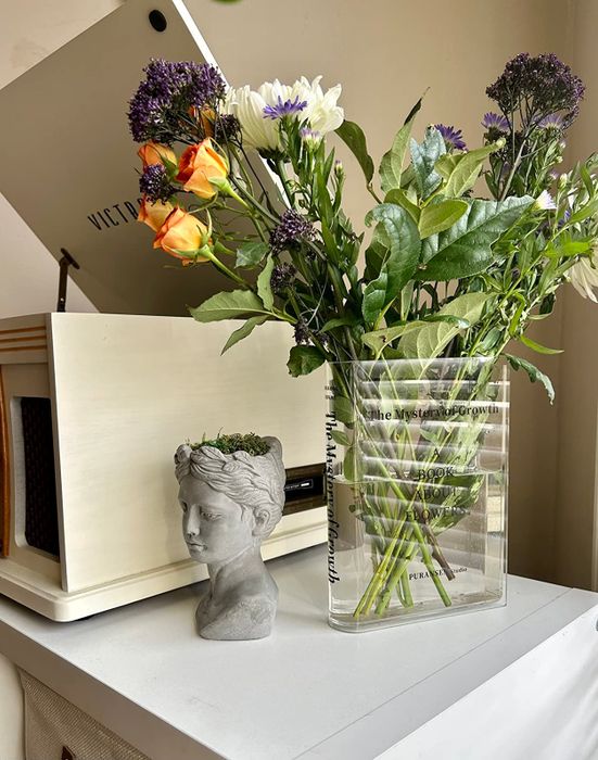 A reviewer’s book-shaped flower vase with flowers spilling out of it
