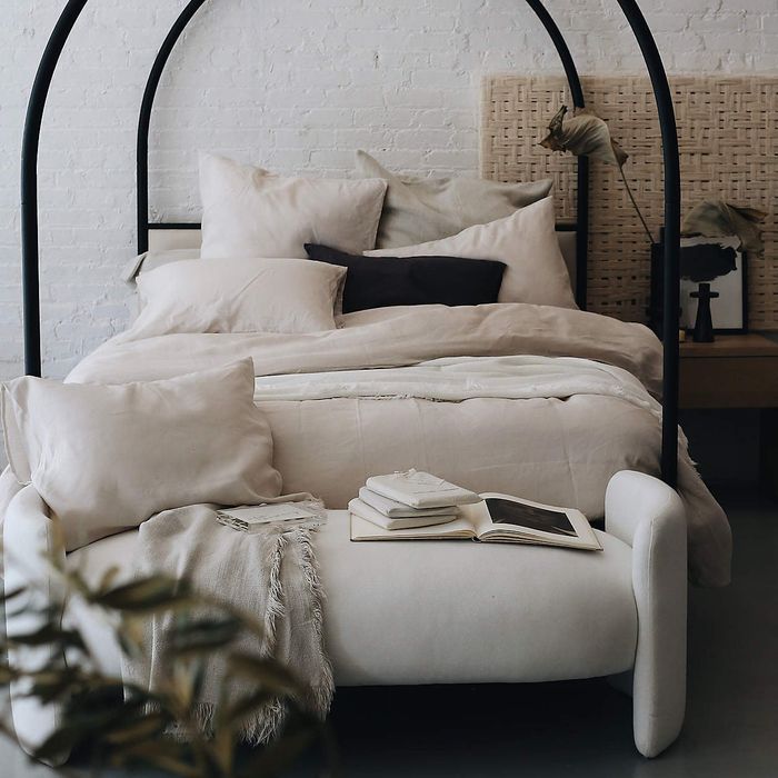 white upholstered bench positioned at the foot of the bed