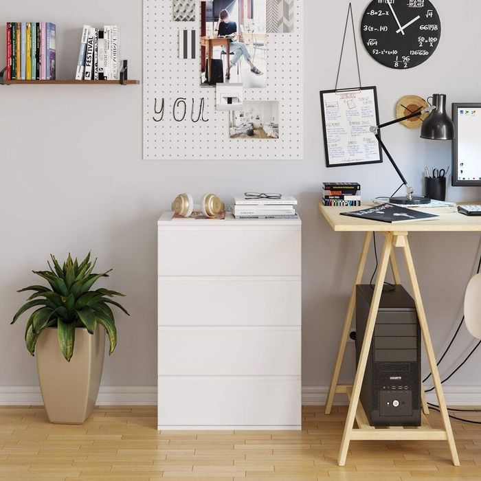 Minimalist white four-drawer dresser in a home office setting