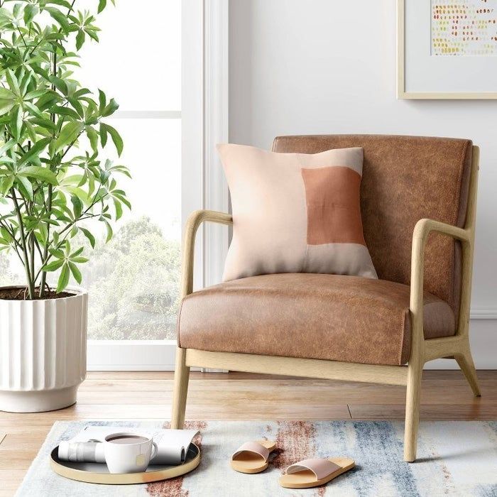 An image of a mid-century wooden armchair featuring a padded seat and backrest.