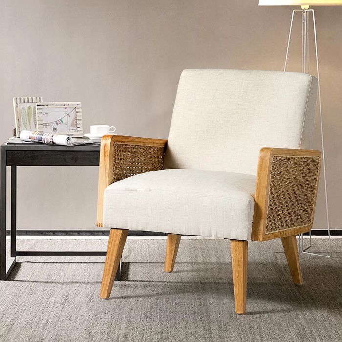 The white rattan chair placed beside a charming side table, creating a cozy, inviting nook.
