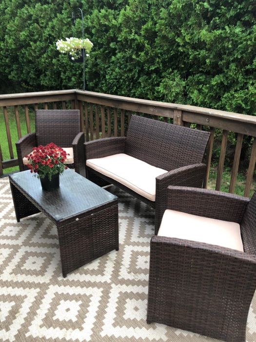 Reviewer photo of the brown patio furniture with cream cushions on a deck.