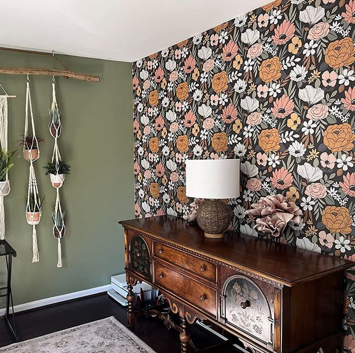 A reviewer’s home office with one wall adorned in a mix of pink, white, and black floral wallpaper.