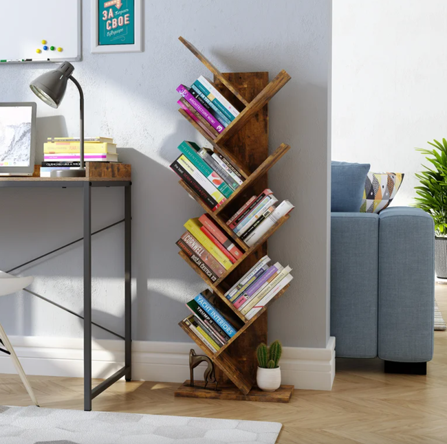 The rustic brown tree bookshelf holding books on six of its tiers