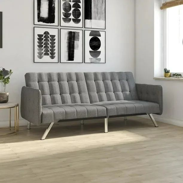 A grey linen couch placed on a hardwood floor.