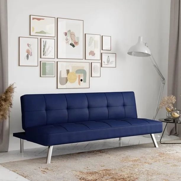 A blue sofa with artwork hanging above it on the wall.