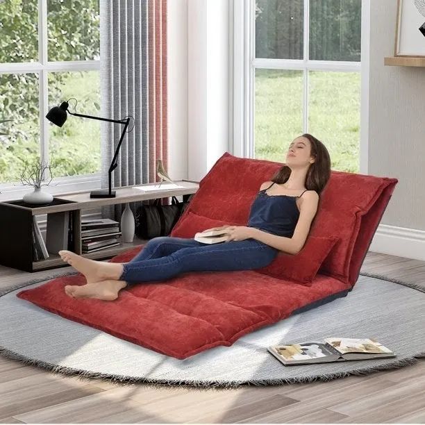 A model relaxing on a red futon, fully extended on the floor
