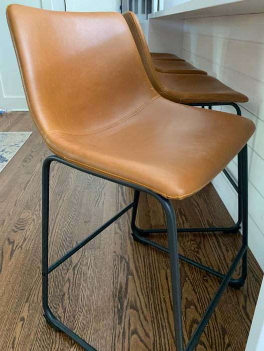 Close-up shot of a tan faux leather barstool as reviewed by a customer