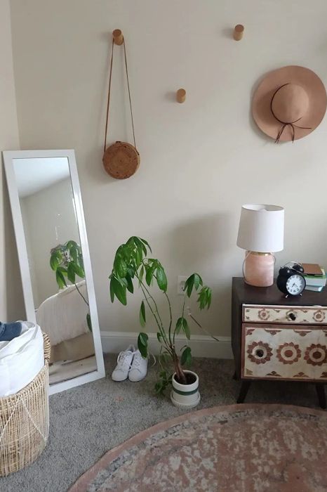 A reviewer using the wooden hooks to hang their accessories on the wall