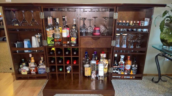 Product shown with doors open, revealing shelves and cubbies stocked with bottles and glasses