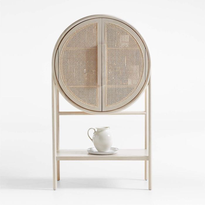 The West whitewashed cane storage cabinet with doors closed