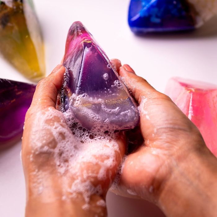 Hands using a gem-shaped soap bar to wash