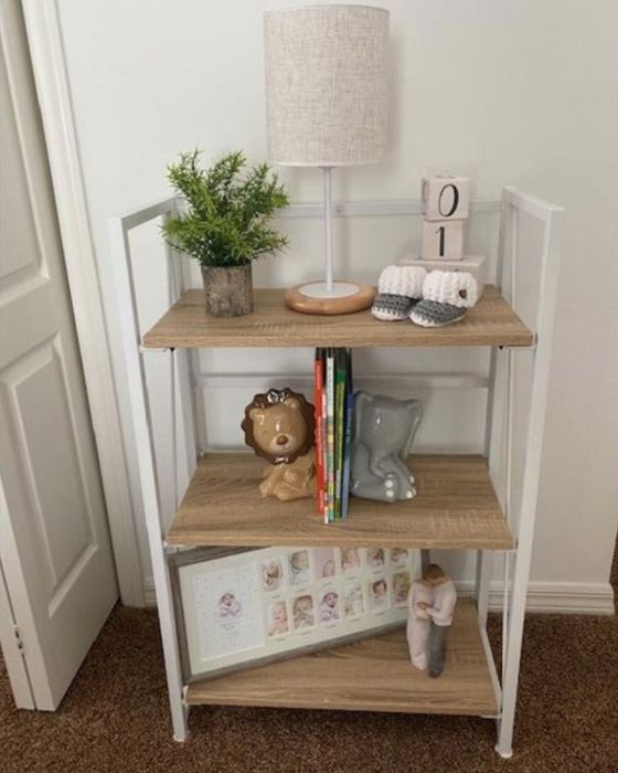 A white and light wood bookcase in a reviewer’s home, featuring books and decor