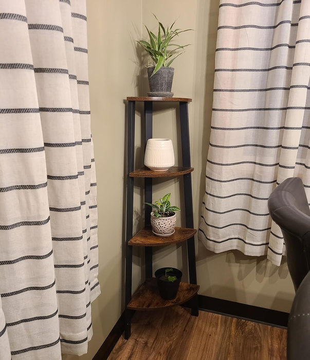 A corner shelf adorned with three potted plants and a white vase, set against striped curtains and a wooden floor