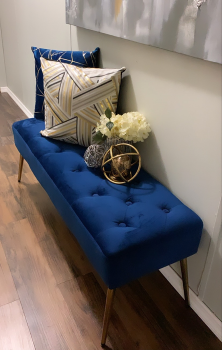 a blue tufted bench placed in an entryway