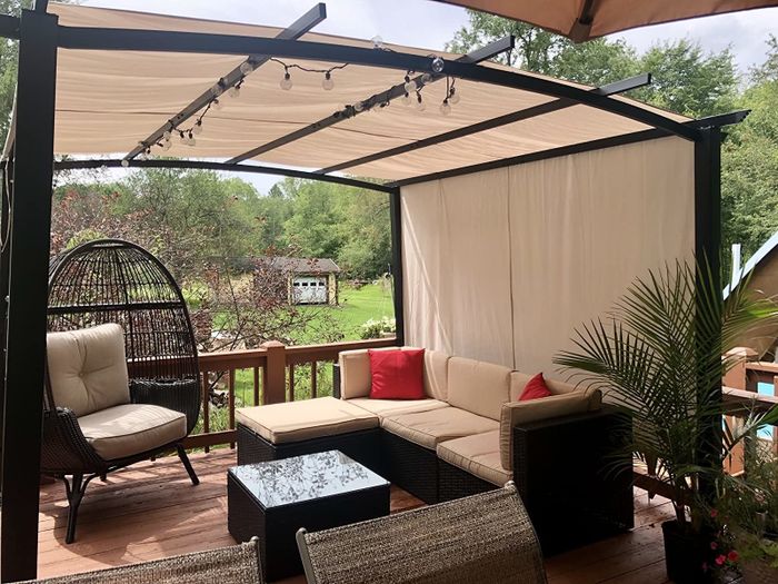 Reviewer photo of a shaded backyard deck setup, featuring a sectional and other patio furniture.